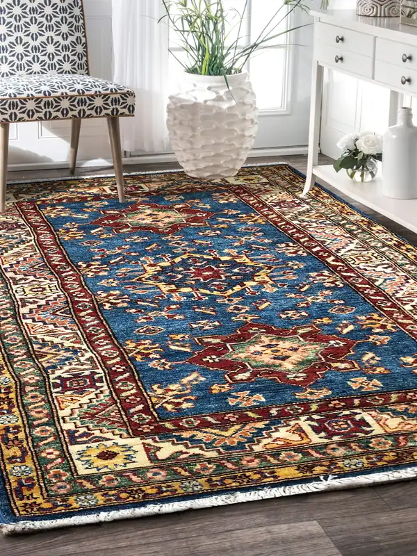 A blue Kazak tribal carpet beside a patterned chair